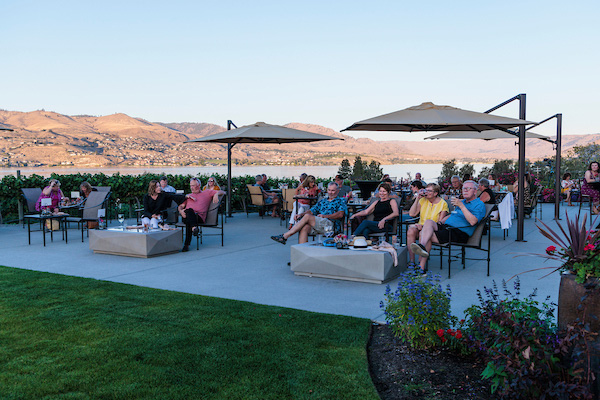people sitting on patio of winery with wine